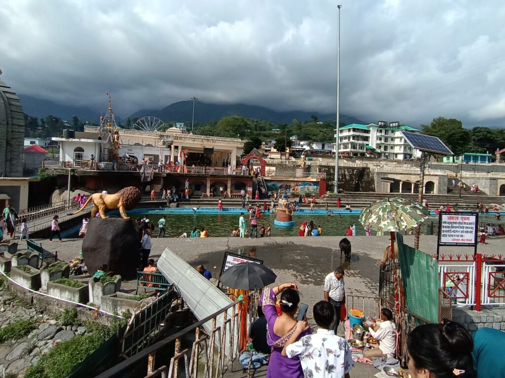 Chamunda Devi Temple distant view with pilgrims enjoying in the pool.