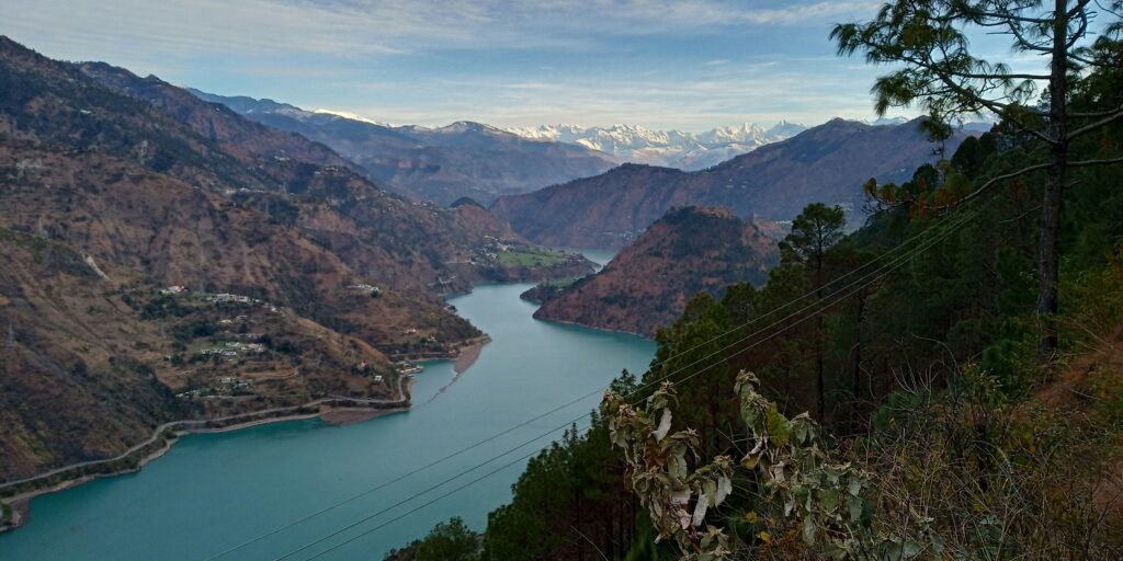 Ravi River flowing gracefully between lush green mountains.